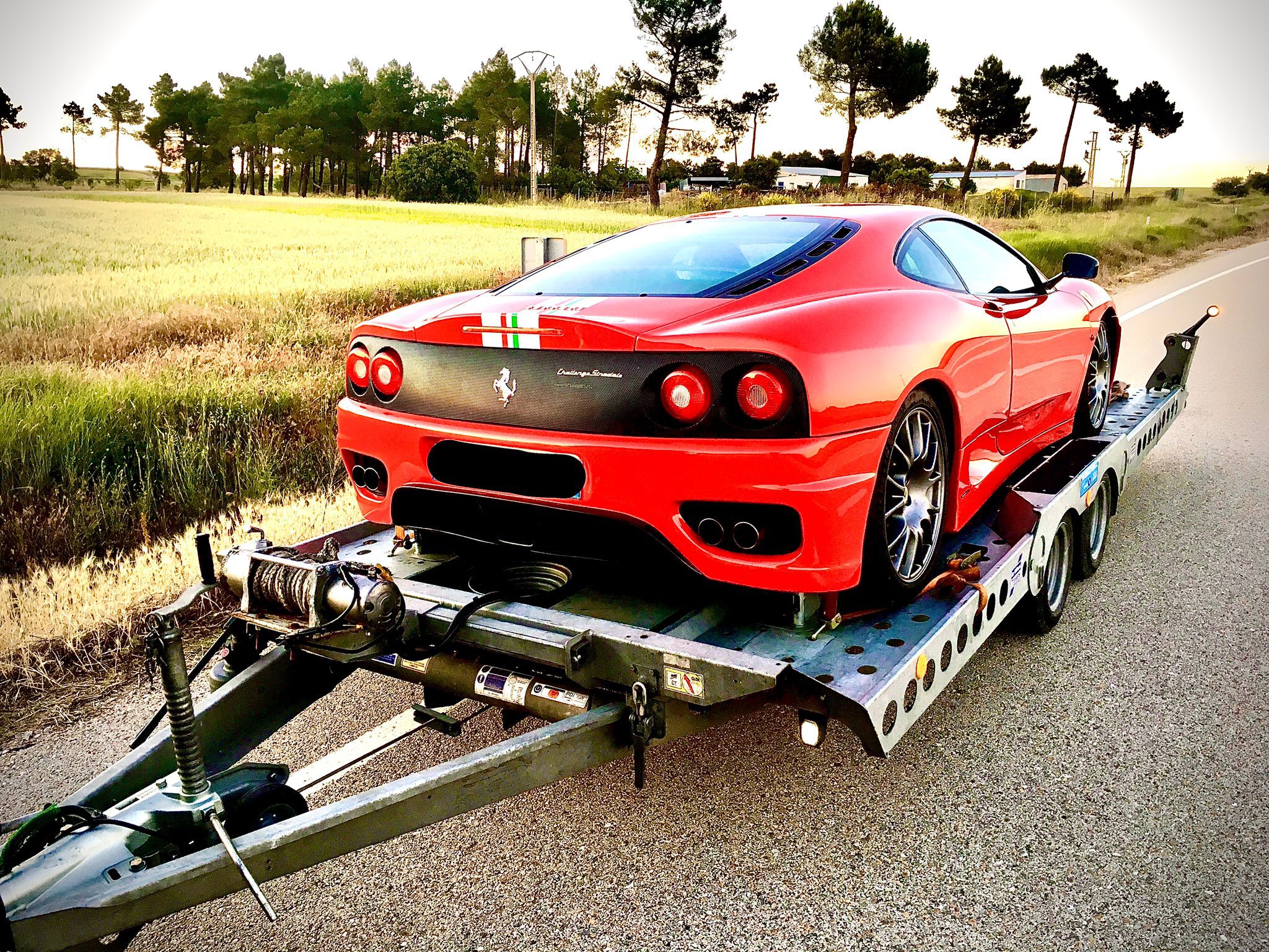 Ferrari rojo cargado en la plataforma abierta Ifor Williams CT177 de Enduro Rent